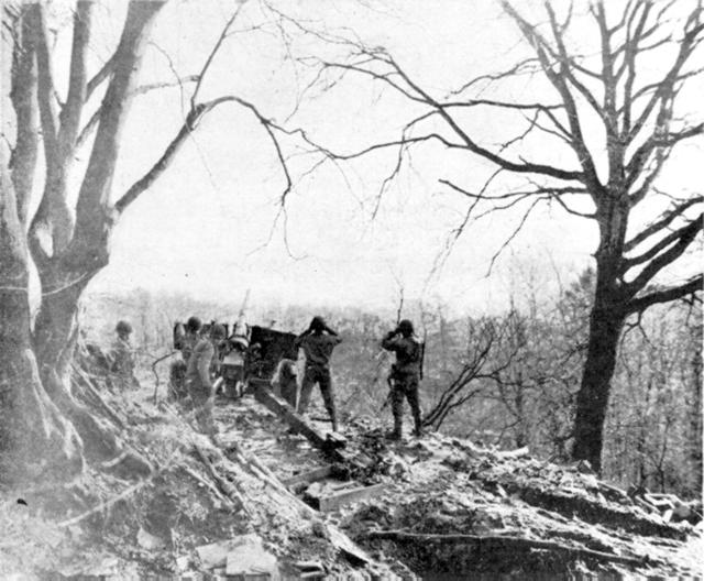 Three inch gun firing over Saar River at fortified town of Dilligen, Germany