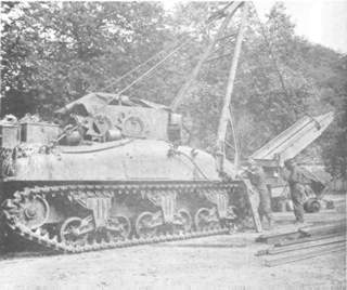 Welding a bridge to a tank wrecker.