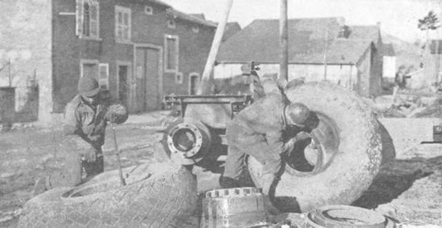 Repairing the huge tires for a gun-carrier.