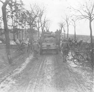 The infantry, supported by tanks, moves through the dragon teeth of the Siegfried Line.